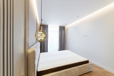 Büyük yataklı ve ışıklandırmalı bir odanın iç tasarımı.