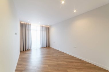 Perdeleri ve zemini olan temiz, ferah bir oda.