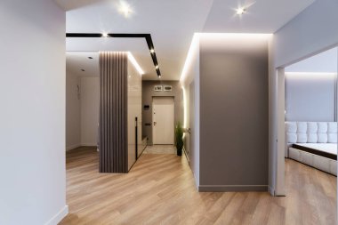 Ahşap duvarları ve beyaz kapıları olan bir koridor. Eve giriş.