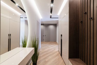 Evin içinde yeni parlak bir ayna ve koyu ahşap bir duvar var.