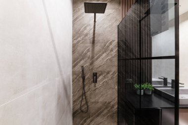 Banyo içi kiremitlerle ve cam koyu duvarlarla kaplı.