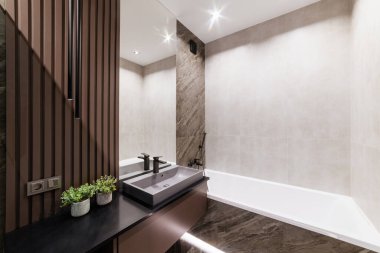 Ayna banyosu ve ahşap kaplı şık bir banyo.