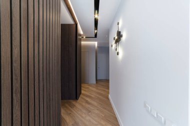 Evin içi temiz, ahşap bir duvar ve zemin var.