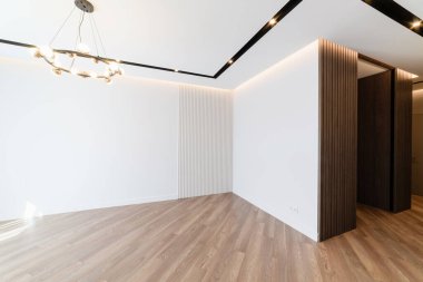 Beyaz oda içinde siyah lamba ve ahşap zemin