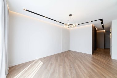 Karanlık zemini ve aydınlığı olan boş beyaz bir odanın içinde.