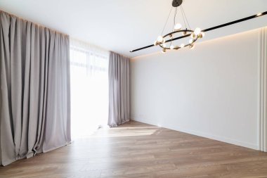 Büyük bir lamba penceresi olan yeni beyaz bir odanın içi.