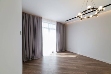 Geniş pencereli ve perdeli parlak bir odanın iç tasarımı