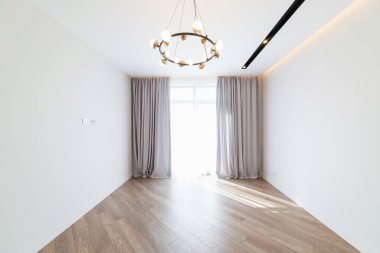 Büyük bir penceresi ve zemini olan beyaz bir odanın içi.