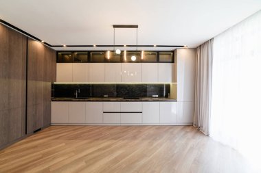 Koyu zemini olan bir evde beyaz bir mutfağın yeni iç mekanı.