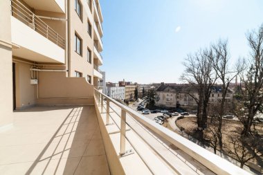 Evin içinde parlak, boş bir balkon vardı. Metal parmaklıklar