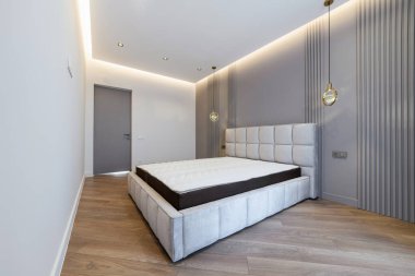 Büyük bir yatağı ve ışığı olan uyku odasının içi.