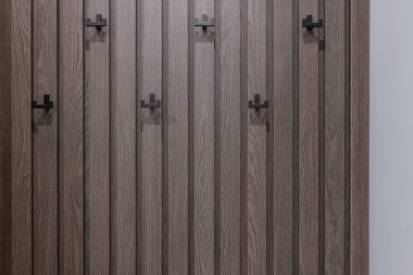 arkaplan için resim. Siyah kancalı bir şeritte kahverengi ahşap duvar