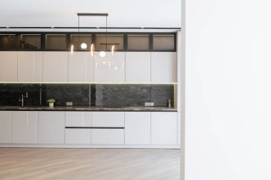 Aydınlatma tarzında yeni bir beyaz mutfak.