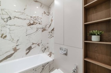 Beyaz küvetli ve odunlu yeni banyo.