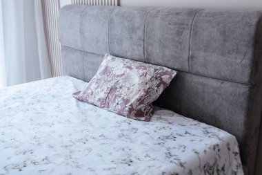 Uyumak ve dinlenmek için büyük, gri, temiz yatak.