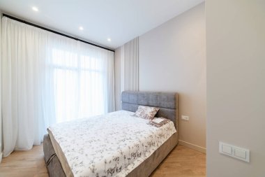 Büyük bir yatağı ve penceresi olan bir oturma odası.