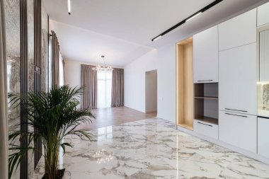 Beyaz bir mutfağı ve geniş bir penceresi olan yeni, parlak bir ev.