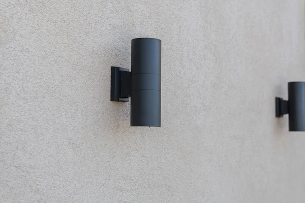 Duvarda siyah metal lambalar var.