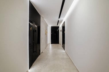 Siyah kapıları ve ışıkları olan yeni parlak bir koridor.