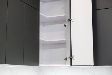 Siyah cepheli mutfak mobilyalarının kapılarını aç.