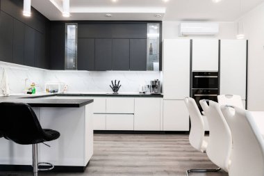 Büyük, yeni mutfak, beyaz sandalyeler ve masa.