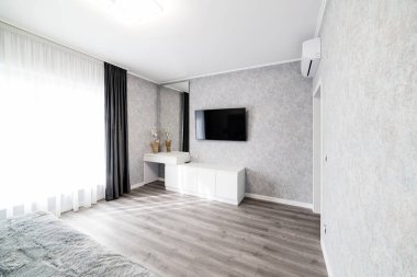 Parlak, geniş pencereli ve televizyonlu yeni bir oda.