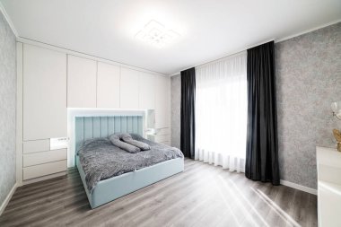 Büyük yataklı, parlak renklerde uyumak ve dinlenmek için bir oda.
