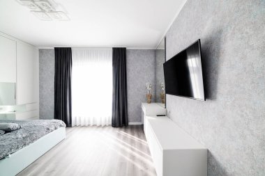 Televizyon ve uyumak için yatak olan parlak bir oda.