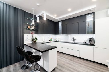 Siyah üst ve beyaz tabanlı şık bir mutfak.