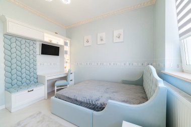 Modern, parlak bir iç tasarım, yataklı ve masalı bir çocuk odası.