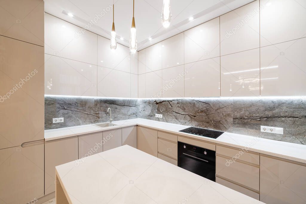 New clean empty light kitchen with large countertop and backlight