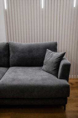 Odanın içinde dinlenmek için siyah yeni bir kanepe.