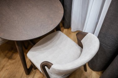 Hafif, yeni, temiz bir sandalye ve mutfaktaki doğal ahşaptan yapılmış karanlık bir masa.