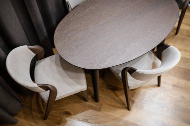 Arkasında doğal ahşap ve sandalyelerden yapılmış temiz, geniş bir oval masa. en üstteki görünüm