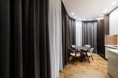 Masalı mutfak, sandalyeler ve büyük perdeler.