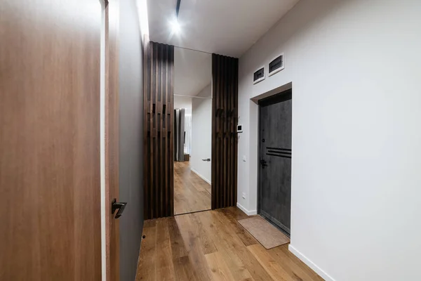 Corridor in the house with a black and white wall and a wardrobe made of wood