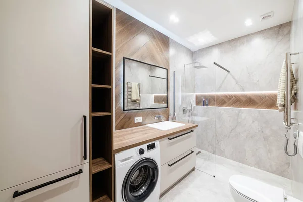 Duş ve arka ışığı olan yeni, tamamen şık bir banyo.