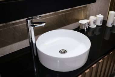 Banyoda metal musluk olan temiz beyaz su lavabosu.