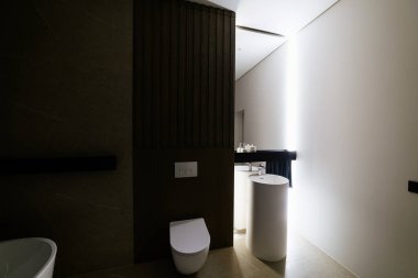 Işıklı ve beyaz duvarlı büyük aynalı yeni bir evin banyosu