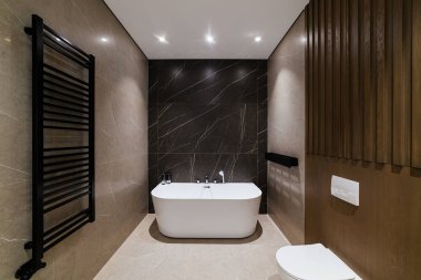 Modern banyo tasarımı. Siyah bir duvarda beyaz bir banyo. Çatı Biçimi