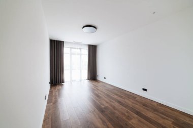 Geniş, büyük, beyaz duvarlı boş bir oda.