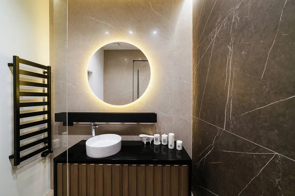 バスルームのモダンなインテリアデザイン ラウンドミラーと黒のカウンタートップ — ストック写真