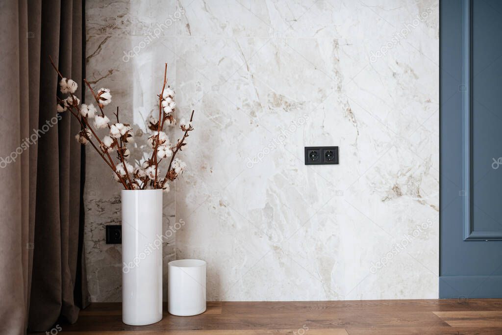 Bright interior of the room with decorative elements, white base and dark floor