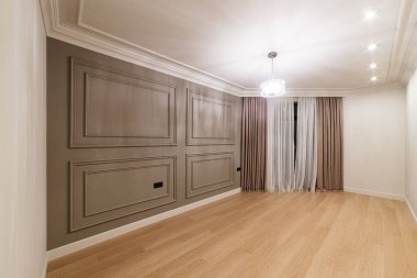 Odanın içi, aydınlık ve karanlık bir duvar, bir pencere ve ahşap bir zemin.