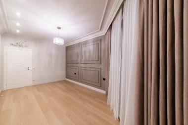 Evin içinde perdeleri ve lambası olan büyük bir oda.