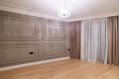 Evin içinde bir yerde. Odanın dekorasyonu, kahverengi duvarlı, geniş perdeli ve tüllü.