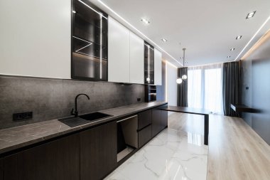 Stüdyo mutfağının karanlık ve aydınlık mobilyalı modern iç mekanı.