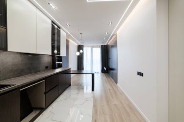 Mutfak stüdyosunun içi karanlık ve aydınlık mobilyalarla dolu.