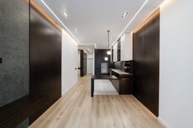 Geniş, temiz bir oda ve karanlık bir mutfak.