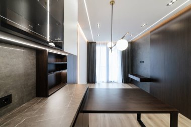 Karanlık ve aydınlık cephelerle dolu bir masası ve penceresi olan yeni bir mutfak.